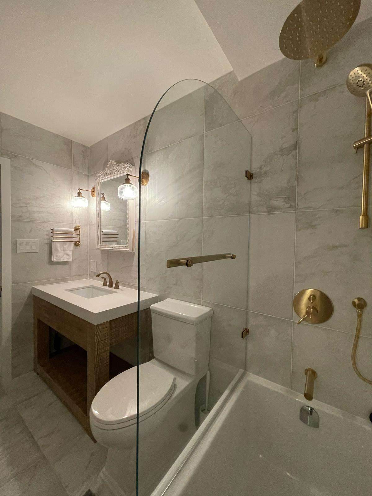 Finished bathroom with glass shower and brushed gold fixtures