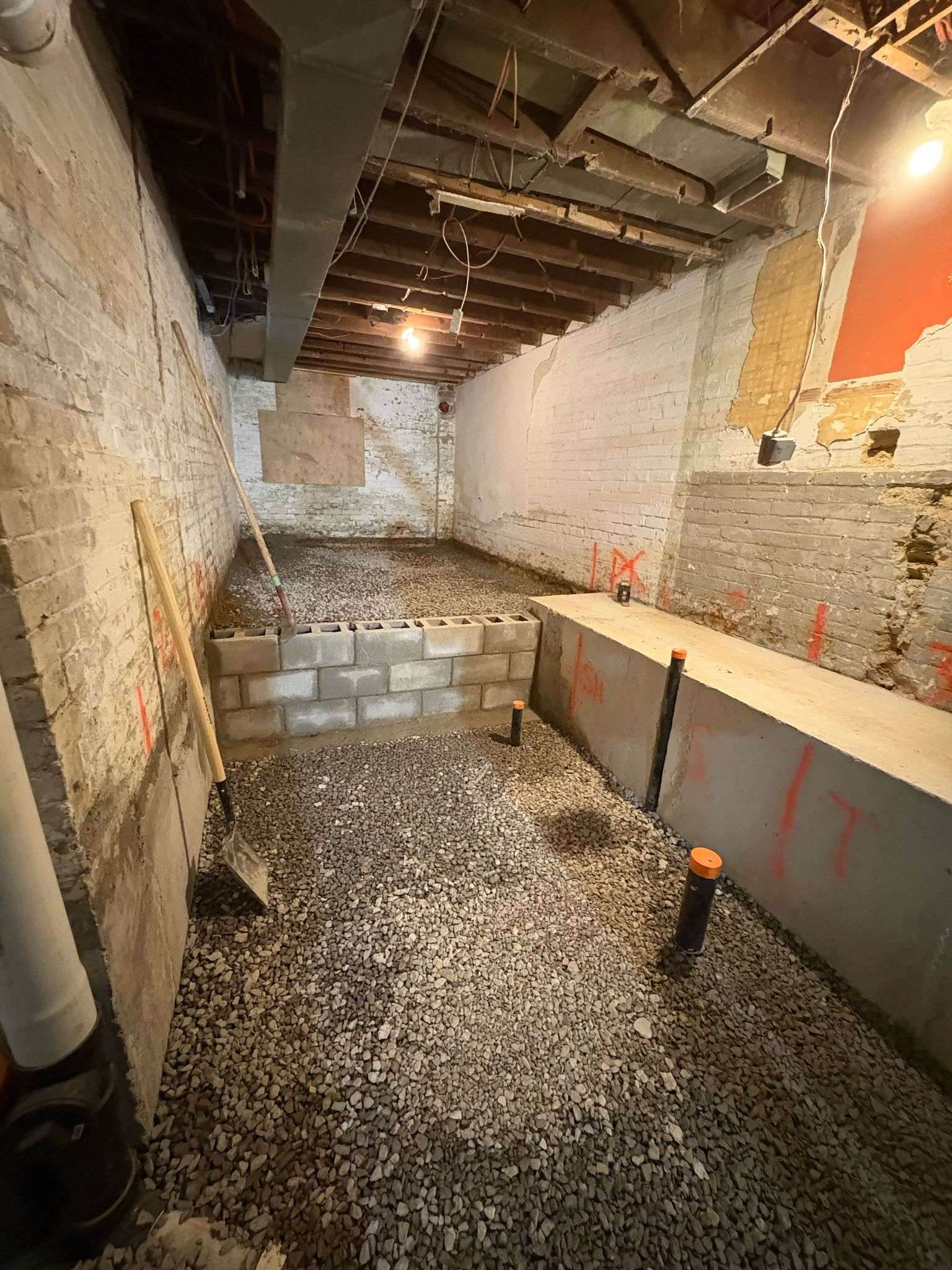 Lowered basement with new underpinned walls and a compacted gravel base before the slab